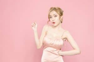 上を指さすドレスの女性