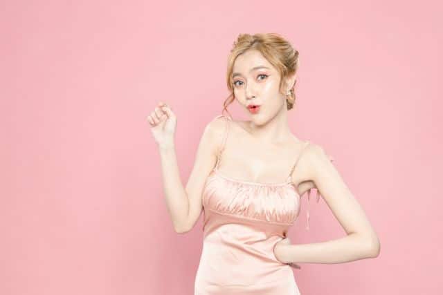 上を指さすドレスの女性