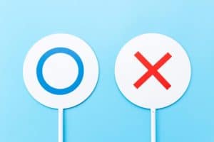 水色の背景の前にあるマルバツの札